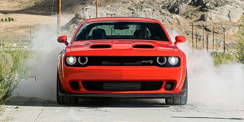 A photo of the front grill of a red Dodge Challenger